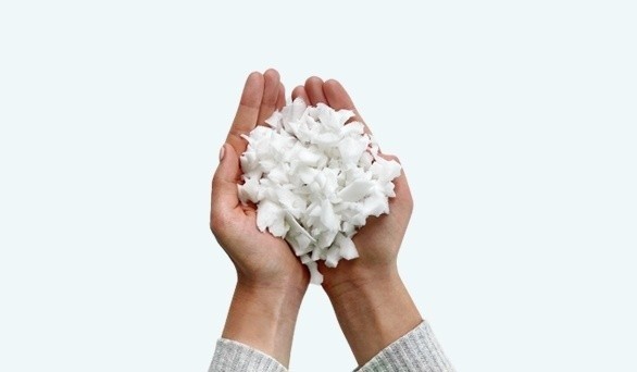 A birds eye view of hands holding the Sealy Adjustable Pillow filling pieces, mobile view